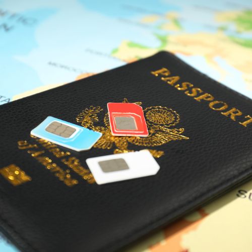 Passeport posé sur une carte du monde avec trois cartes ESIM colorées, symbolisant le voyage international.